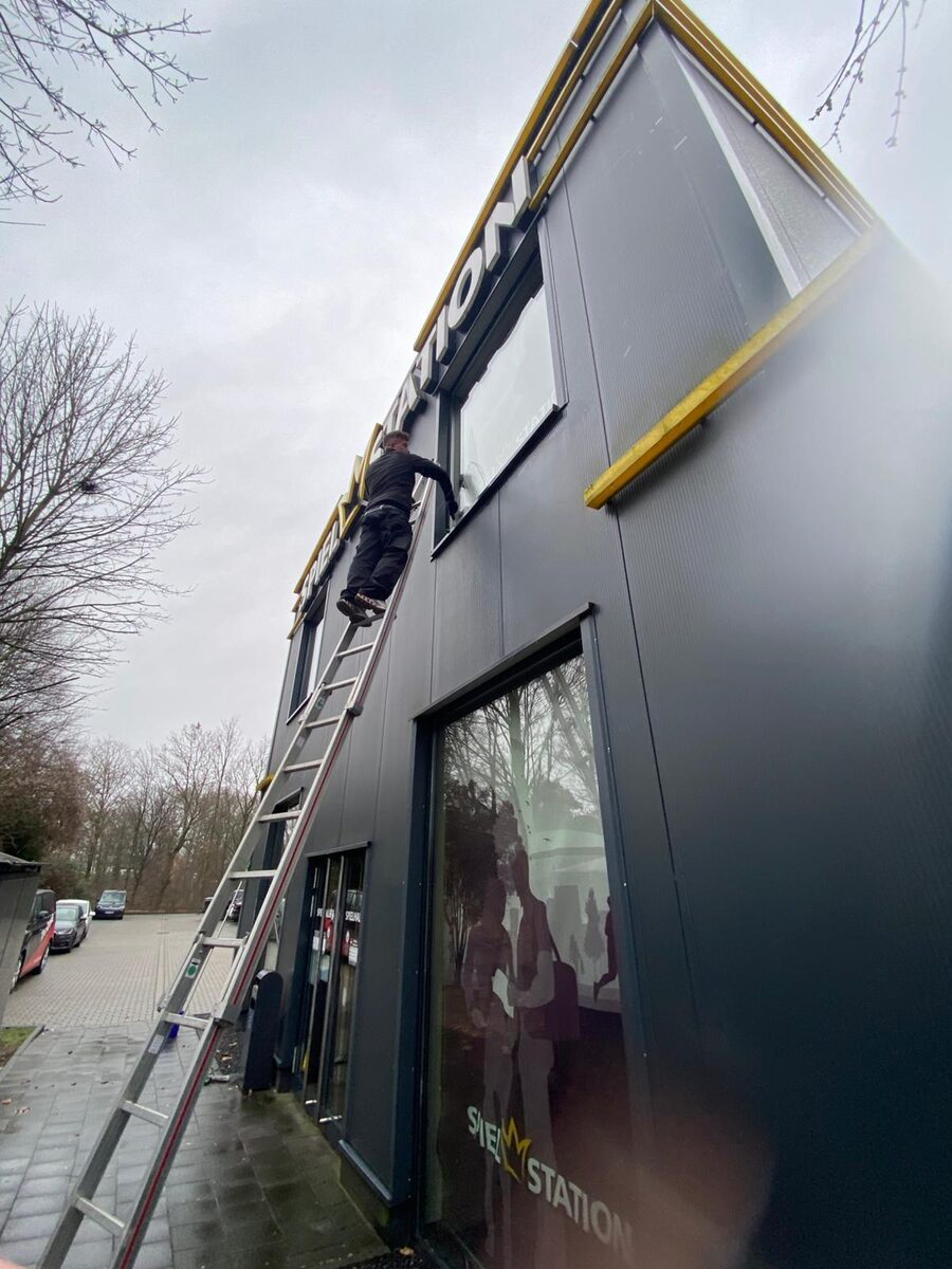 Hermanos Gebäudereinigung bei der Glasreinigung an einer Gewerbefassade in Köln